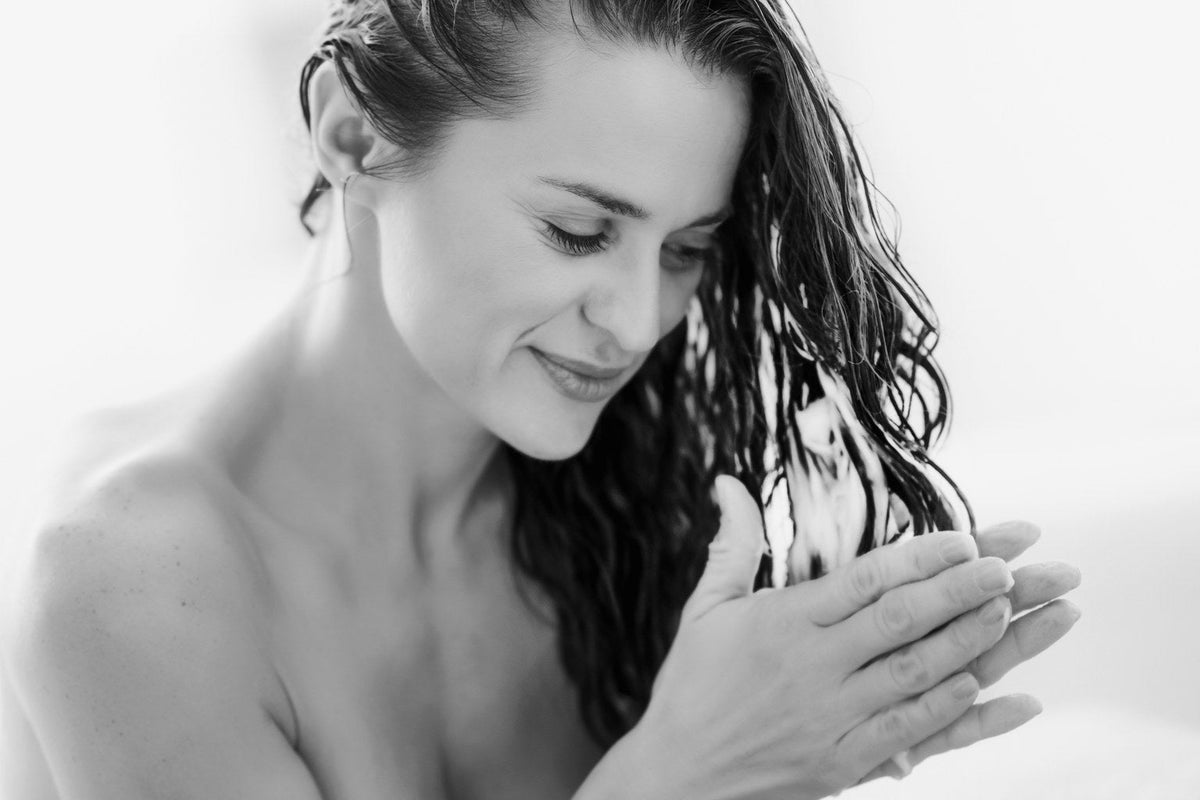 Woman massaging shampoo through wet hair, black and white, best Japanese shampoos guide from Kija Hair Salon